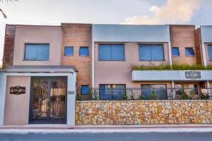 un edificio con una pared de piedra y una valla en Pousada Bella Casa en Balneário Camboriú