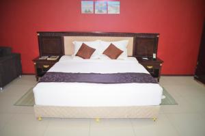 1 dormitorio con 1 cama grande y 2 mesitas de noche en Riverside Hotel, en Lilongwe