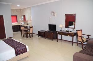 a bedroom with a bed and a desk and a kitchen at Riverside Hotel in Lilongwe