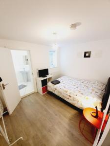 a small bedroom with a bed and a desk at Chelmsford Town Centre New Modern Apartments in Chelmsford