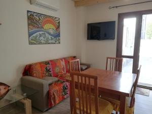 a living room with a table and a couch at Casa Tommy in Olbia