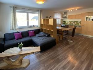 a living room with a black couch and a table at Ferienwohnung Bernadette in Goldegg