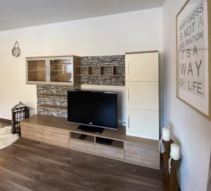 a living room with a flat screen tv on a dresser at Ferienwohnung Bernadette in Goldegg