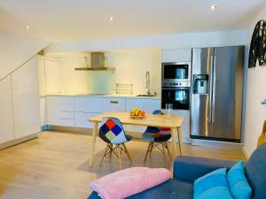 una cucina e un soggiorno con tavolo e divano blu di MIMAR ALTEA STUDIO urban ad Altea
