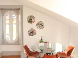 une salle à manger avec une table et des chaises en verre dans l'établissement Sao bento stylish cozy apt with ac balcony, à Lisbonne