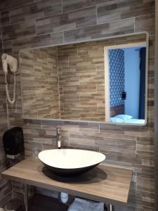 a bathroom with a sink and a mirror at Hôtel De La Perdrix Rouge in Paris