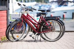 Ein rotes Fahrrad, das auf einem Bürgersteig neben einem Gebäude geparkt ist in der Unterkunft Hotel Strandbo in Nauvo