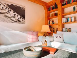 a living room with two white couches and bookshelves at Rehwiesa A33 in Arosa