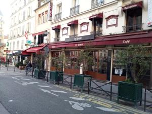 a row of stores on a city street at Hôtel De La Perdrix Rouge in Paris