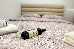a bottle of wine laying on top of a bed at Apartman Frida in Nikšić