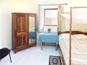 a bedroom with a bed and a table and a mirror at 3 bedrooms appartement at Majunga 100 m away from the beach with furnished terrace in Mahajanga