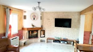 ein Wohnzimmer mit einem Kamin und einem Flachbild-TV in der Unterkunft Villa de 4 chambres avec piscine privee jardin amenage et wifi a Malaucene in Malaucène