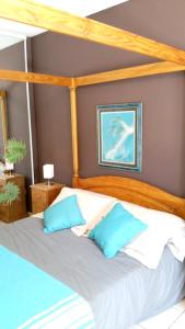 Schlafzimmer mit einem Bett mit blauen und weißen Kissen in der Unterkunft Villa de 4 chambres avec piscine privee jardin amenage et wifi a Malaucene in Malaucène