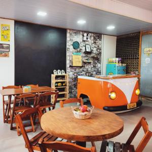 a restaurant with wooden tables and chairs and a counter at Pousada Rota da Kombi in Bom Jardim da Serra