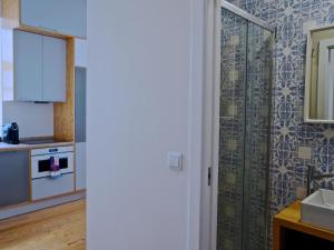 a kitchen with a sink and a shower in a room at Mouraria lovers cozy bright apartment in Lisbon