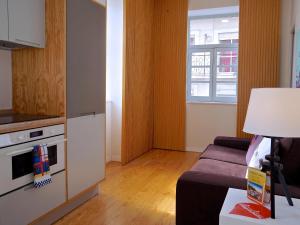 a living room with a couch and a kitchen at Mouraria lovers cozy bright apartment in Lisbon