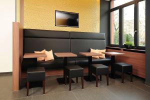 a dining room with two tables and a tv on the wall at GuestHouse Mainz in Mainz