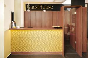 a restaurant with a yellow counter with a guest house sign at GuestHouse Mainz in Mainz