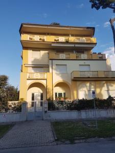 a yellow building with a gate in front of it at Apartamento Vittoria Marina di Pietrasanta in Pietrasanta