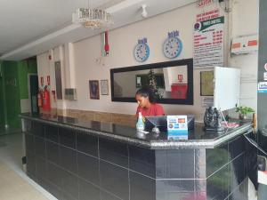 a woman sitting at a counter in a restaurant at Yves Hotel in Porto Velho