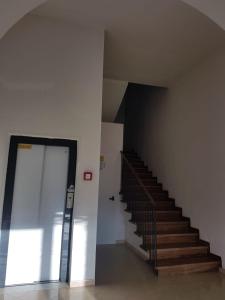a staircase in a building with a glass door at Apartamento Vittoria Marina di Pietrasanta in Pietrasanta