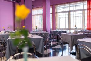 a dining room with tables and chairs and purple walls at La Piramide in Roccalumera