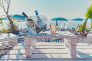 tavolo con bottiglie di vino e bicchieri in spiaggia di La Piramide a Roccalumera