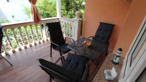 balkon z 3 krzesłami i stołem na ganku w obiekcie Apartment Kreslin w mieście Vantačići