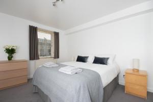 a white bedroom with a bed and a window at Dwellcome Home Ltd 2 Bed Aberdeen Apartment - see our site for assurance in Aberdeen