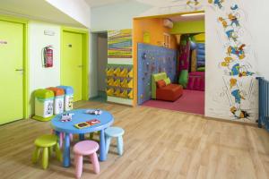 une pièce avec une table et des tabourets et une aire de jeux dans l'établissement Ibiscos Garden Hotel, à Réthymnon 38 autres photos