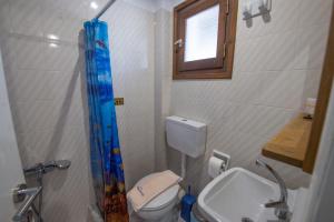 a bathroom with a toilet and a sink and a window at Villa Spyridoula studios on the Beach in Sidari