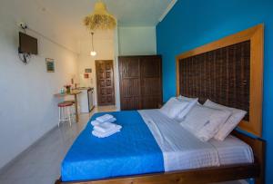 a blue bedroom with a bed with towels on it at Villa Spyridoula studios on the Beach in Sidari