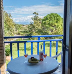 a table with a bottle and two glasses of wine at Villa Spyridoula studios on the Beach in Sidari