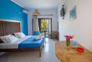 a bedroom with a bed and a table with flowers on it at Villa Spyridoula studios on the Beach in Sidari