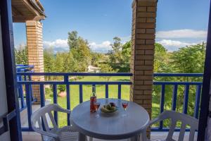a table and chairs on a balcony with a view at Villa Spyridoula studios on the Beach in Sidari