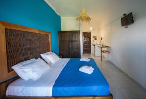 a bedroom with a blue bed with two towels on it at Villa Spyridoula studios on the Beach in Sidari