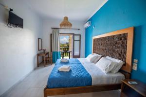 a blue bedroom with a bed with a blue wall at Villa Spyridoula studios on the Beach in Sidari