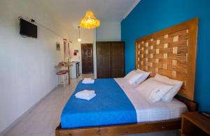 a bedroom with a large bed with blue walls at Villa Spyridoula studios on the Beach in Sidari