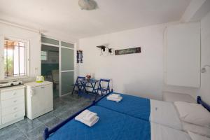 a bedroom with a blue bed and a table at Villa Spyridoula studios on the Beach in Sidari