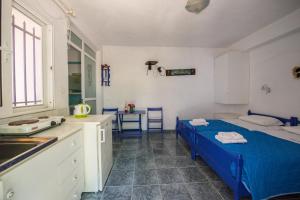 a kitchen with a blue bed in a room at Villa Spyridoula studios on the Beach in Sidari