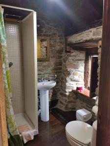 Un baño con lavabo e inodoro en Habitación Cuadruple con derecho a Barbacoa y patio, en Navia de Suarna