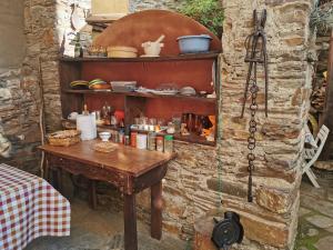una mesa de madera en una pared de piedra con una estantería de madera en Habitación Cuadruple con derecho a Barbacoa y patio, en Navia de Suarna