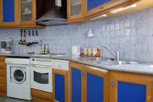 a kitchen with a sink and a washing machine at Villa Spyridoula studios on the Beach in Sidari
