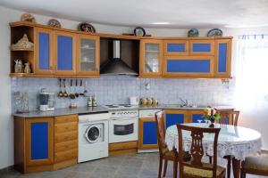 een keuken met blauwe en bruine kasten en een tafel bij Villa Spyridoula studios on the Beach in Sidari