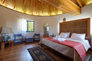 a bedroom with a large bed with a red blanket at Villa Spyridoula studios on the Beach in Sidari