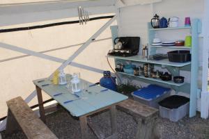 a table and two chairs and a table and shelves at Mill Haven Place glamping yurt 3 in Haverfordwest