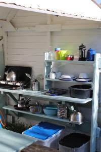 a kitchen with shelves filled with pots and pans at Mill Haven Place glamping yurt 3 in Haverfordwest