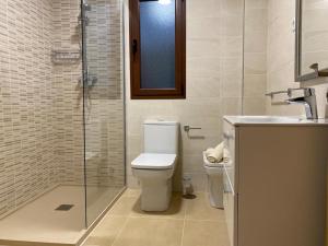 a bathroom with a toilet and a sink and a shower at LANZAROTE VACACIONAL in Arrecife +10 photos