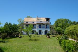 a large white house in the middle of a yard at Villa Spyridoula studios on the Beach in Sidari