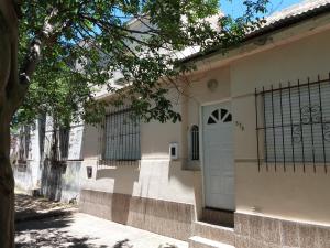 コンセプシオン・デル・ウルグアイにあるUrquiza 575の門と木のある白い建物